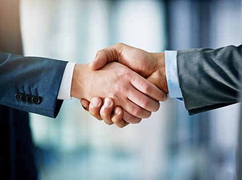 Closeup shot of two businessmen shaking hands in an office